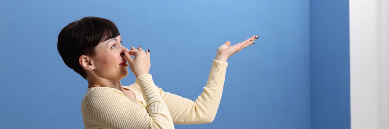 kötü kokudan burnunu kapatan kadın